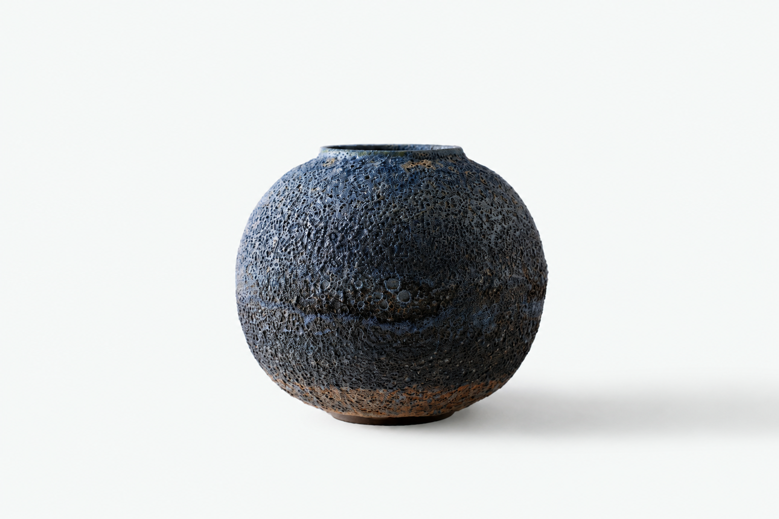Dark rounded Moon Jar with a blue-black volcanic surface