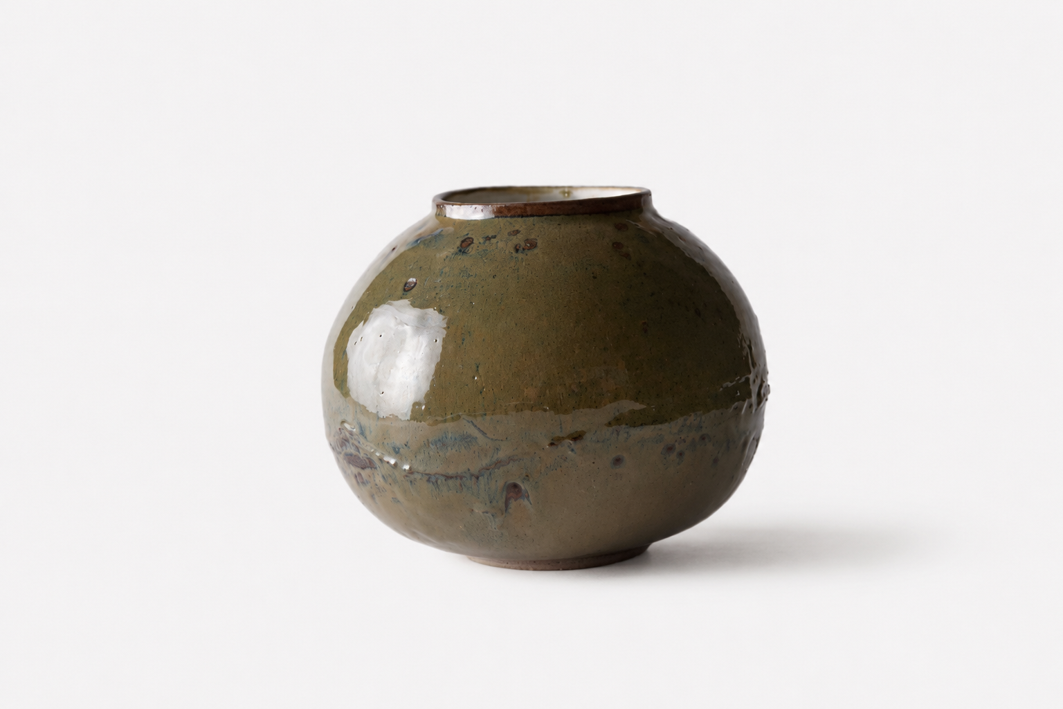 Olive green rounded Moon Jar with a pale gestural glaze mark