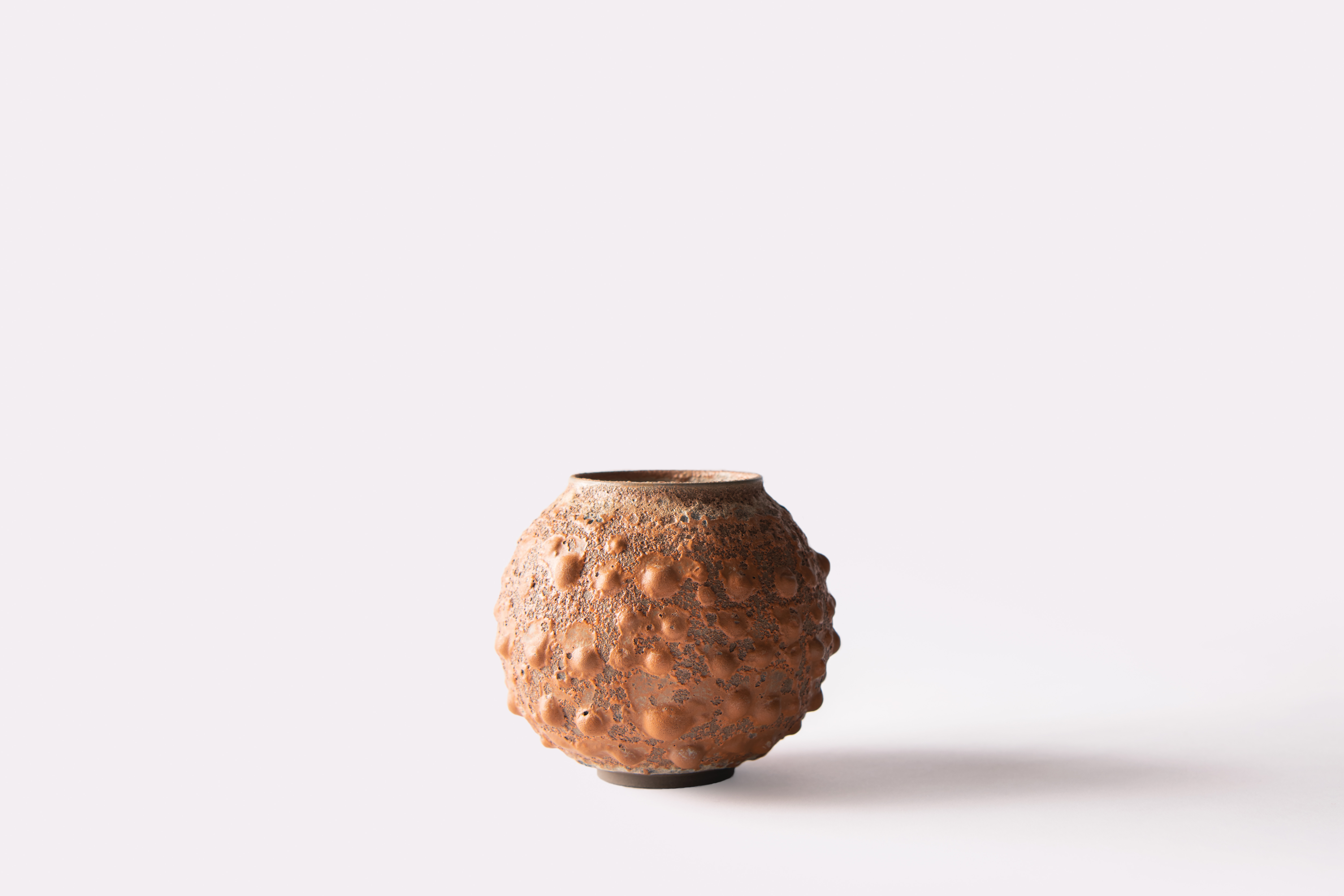Small copper-coloured Moon Jar with a raised textured surface