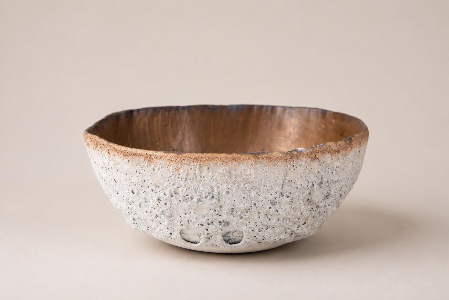 Wide ceramic bowl with a pale volcanic exterior and warm brown interior