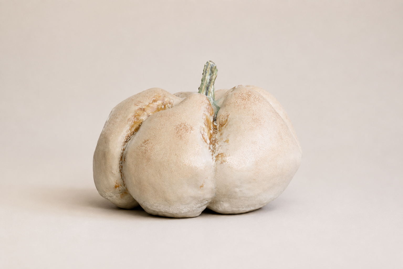 Pale sculptural vessel inspired by a softly segmented organic form