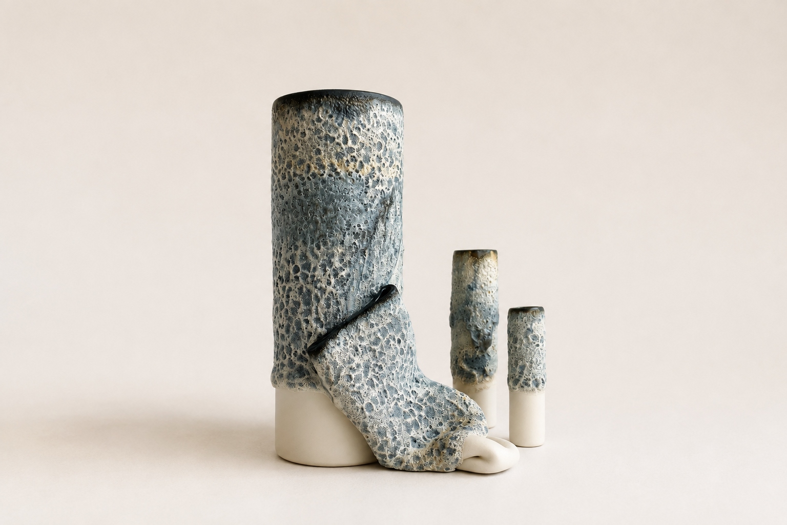 Group of tall pale and blue sculptural ceramic vessels with flowing applied forms
