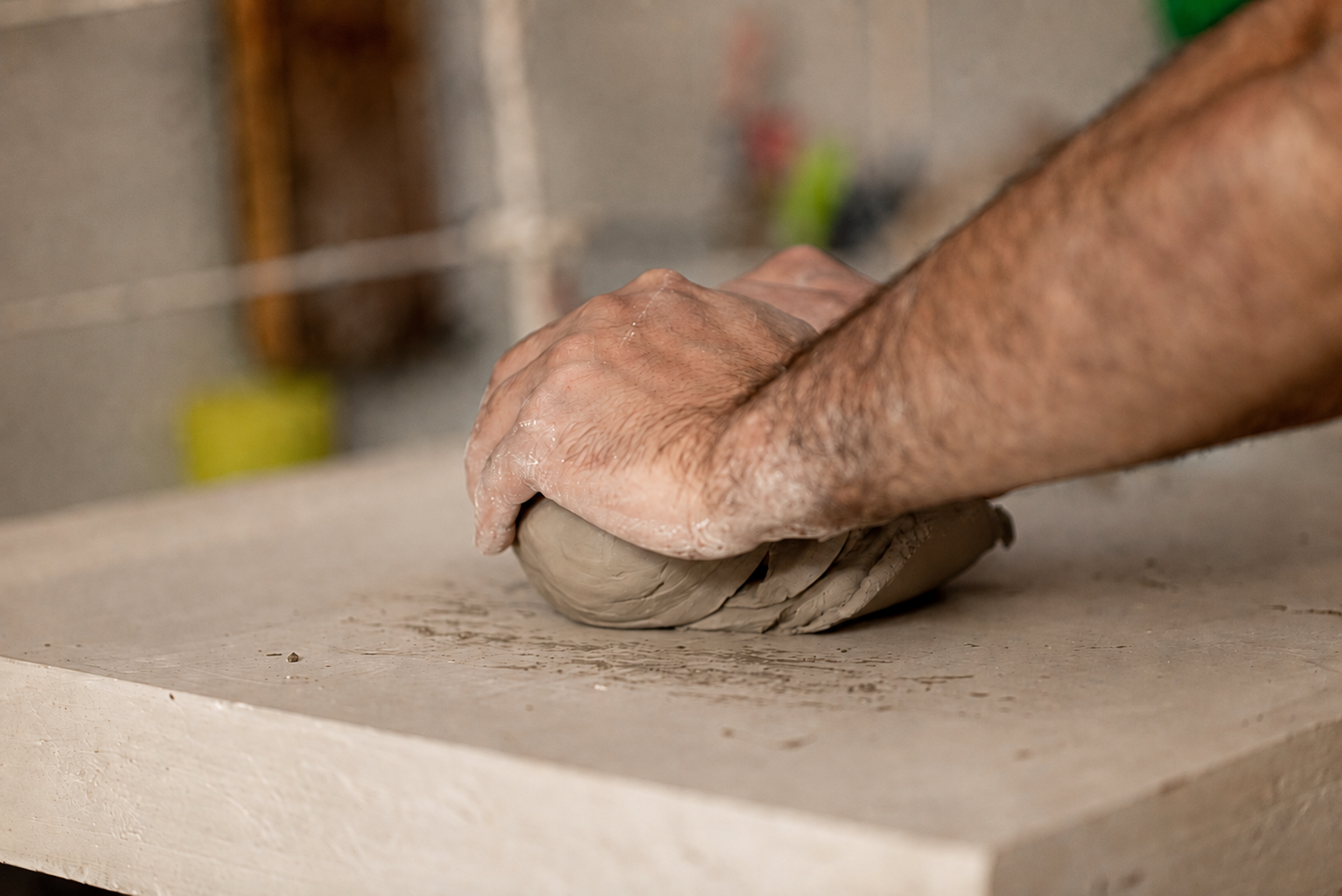 José wedging clay on a studio work surface