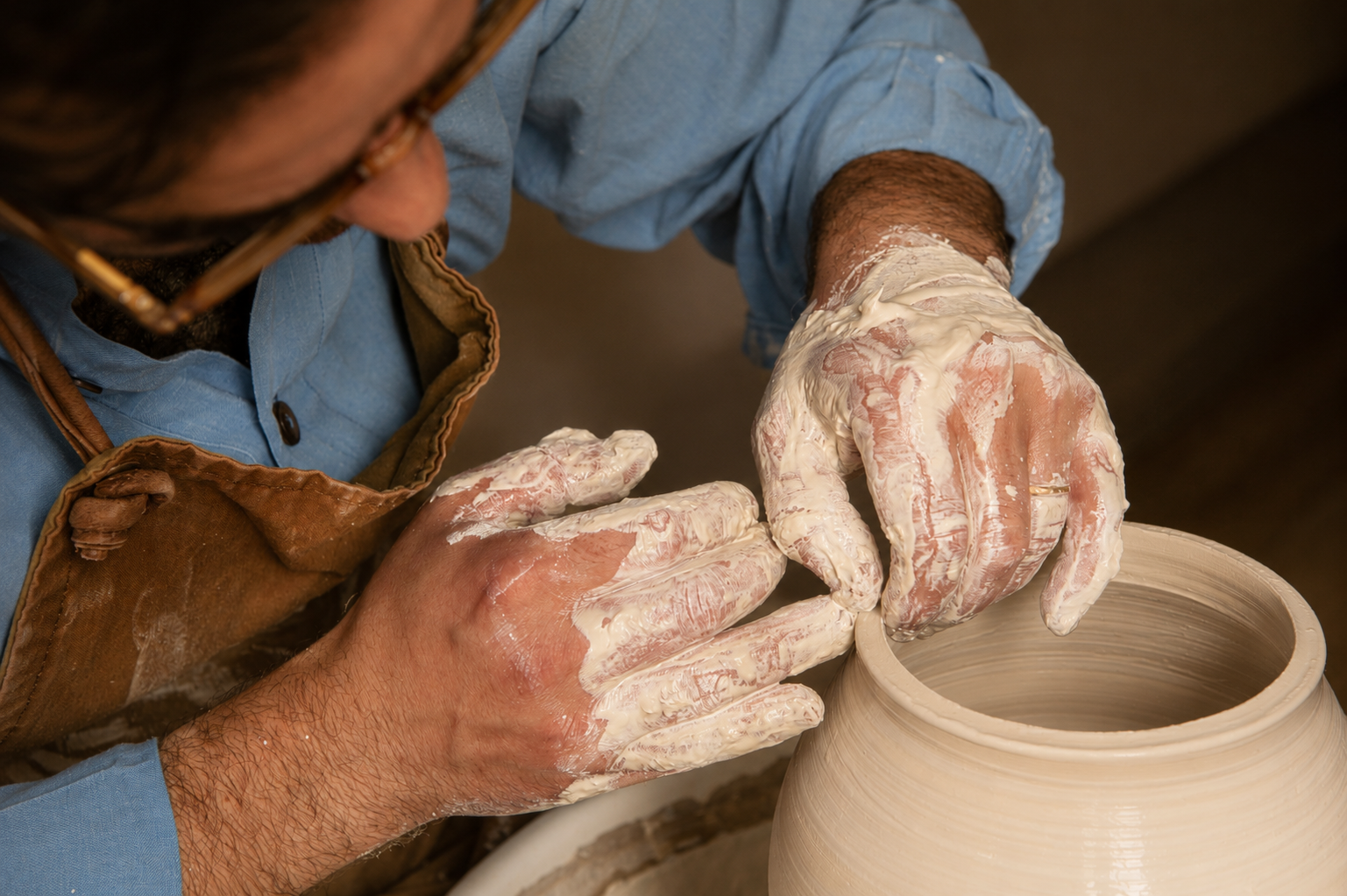José shaping the rim of a freshly thrown vessel