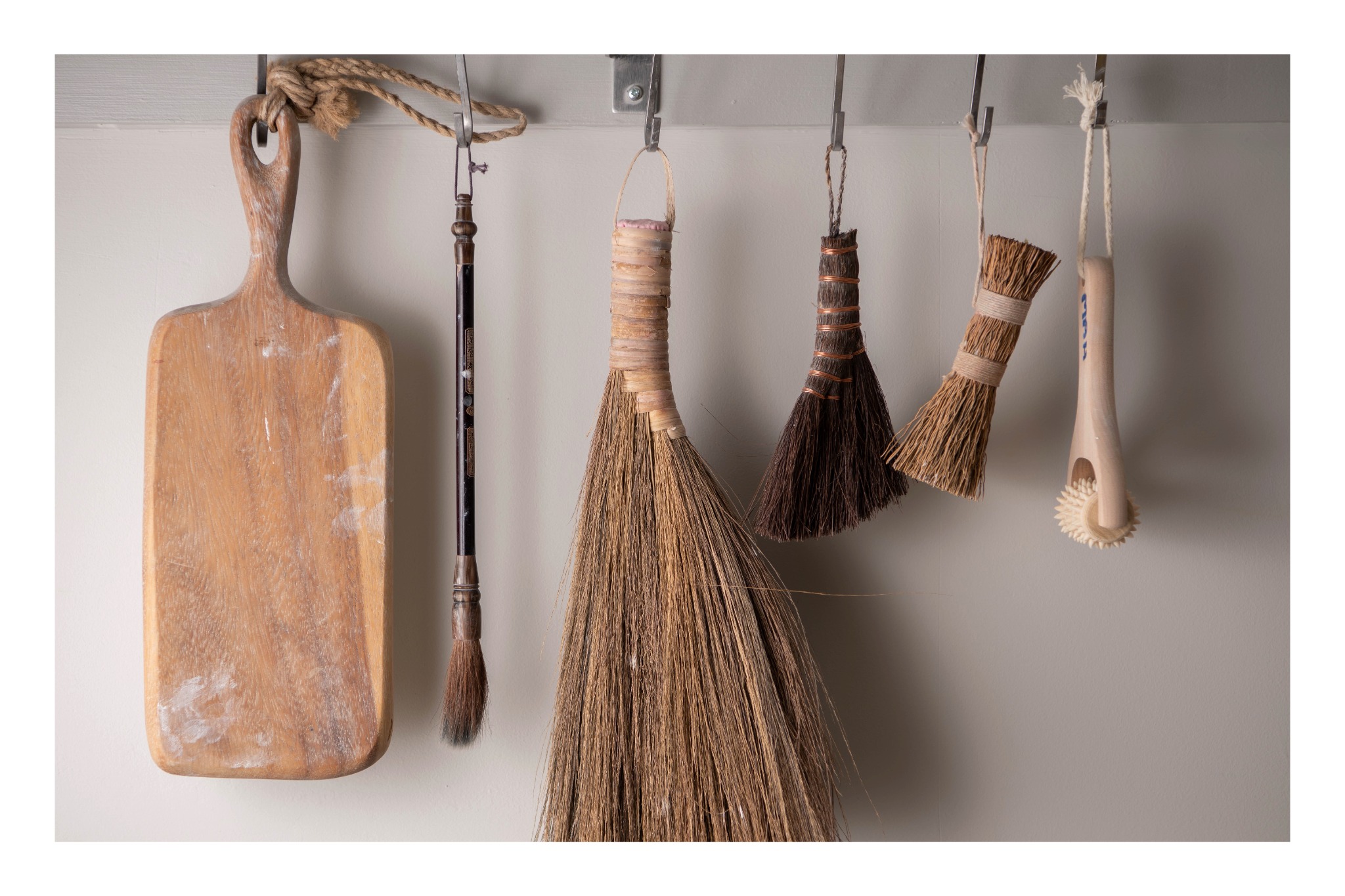Handmade brushes and wooden studio tools hanging within the ceramics studio