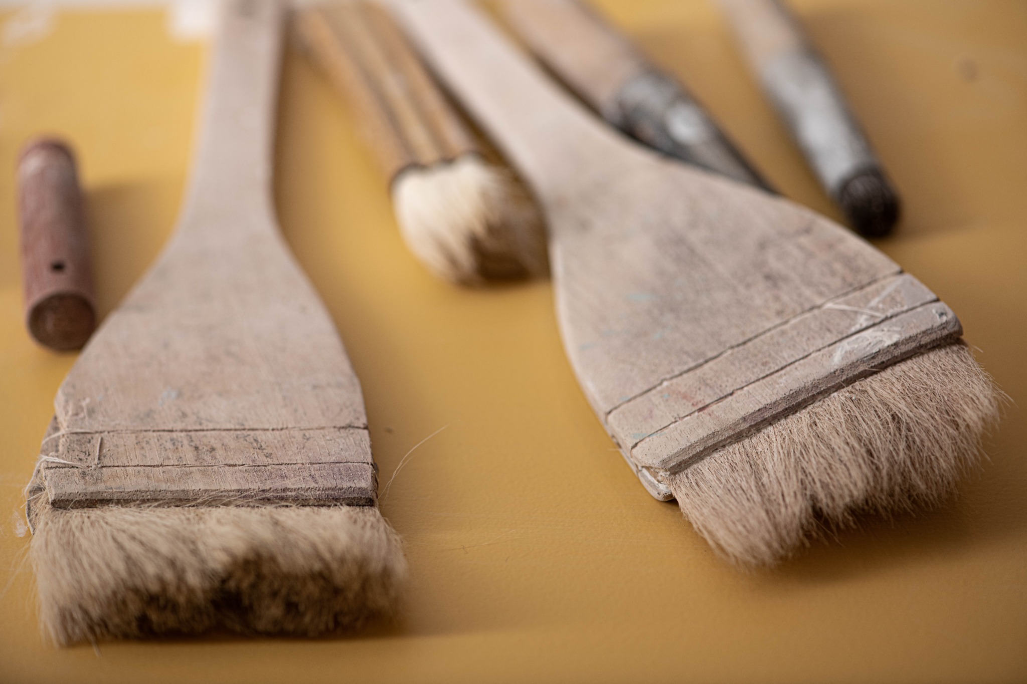 Glaze brushes resting on a studio work surface