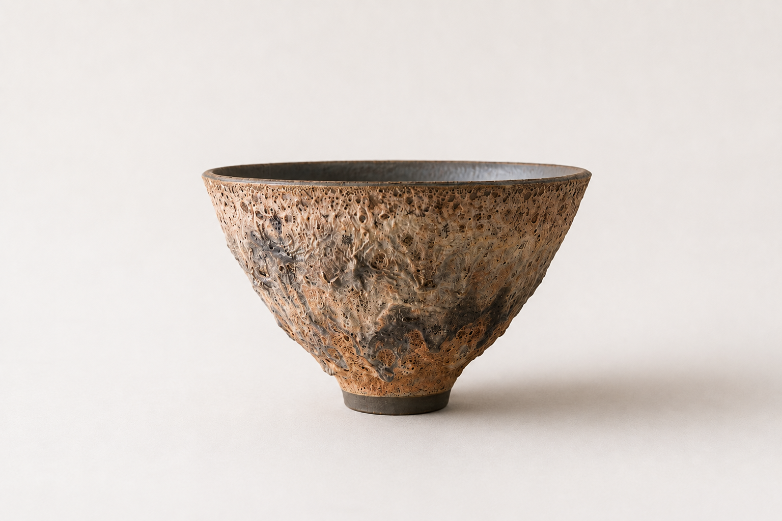 Wide V-shaped vessel with a textured brown volcanic surface