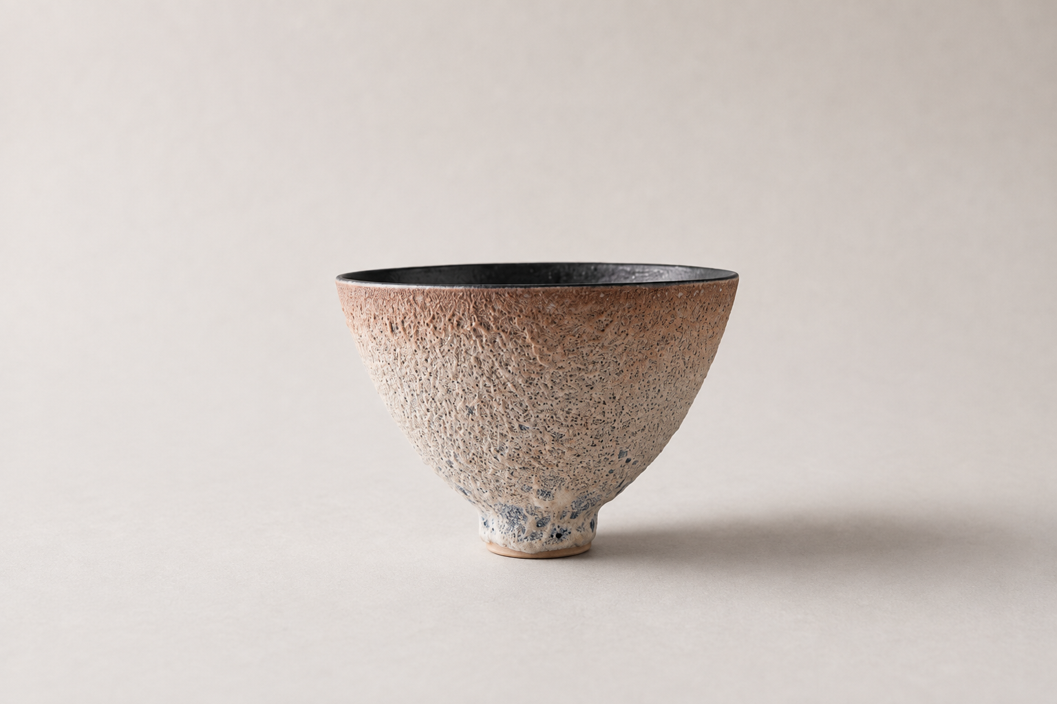 Pale V-shaped vessel with a dark interior and finely textured surface