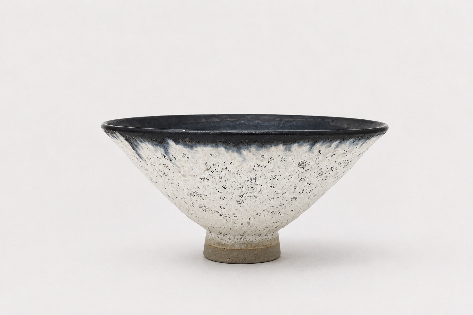 Wide pale V-shaped vessel with a dark glazed rim