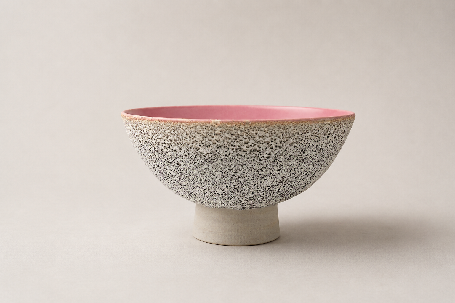 V-shaped vessel with a pale volcanic exterior and pink interior