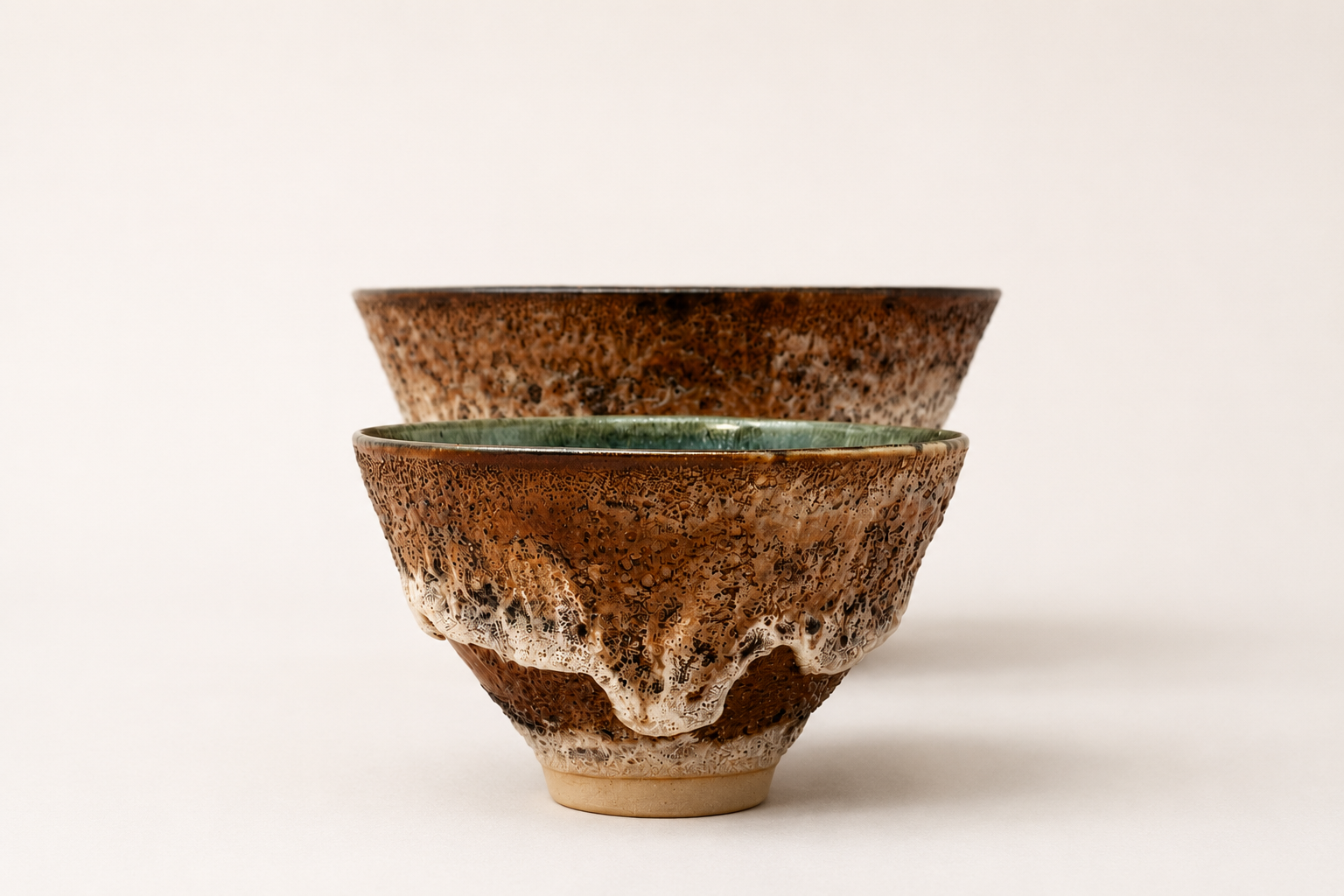 Pair of brown V-shaped vessels with layered cream glaze details