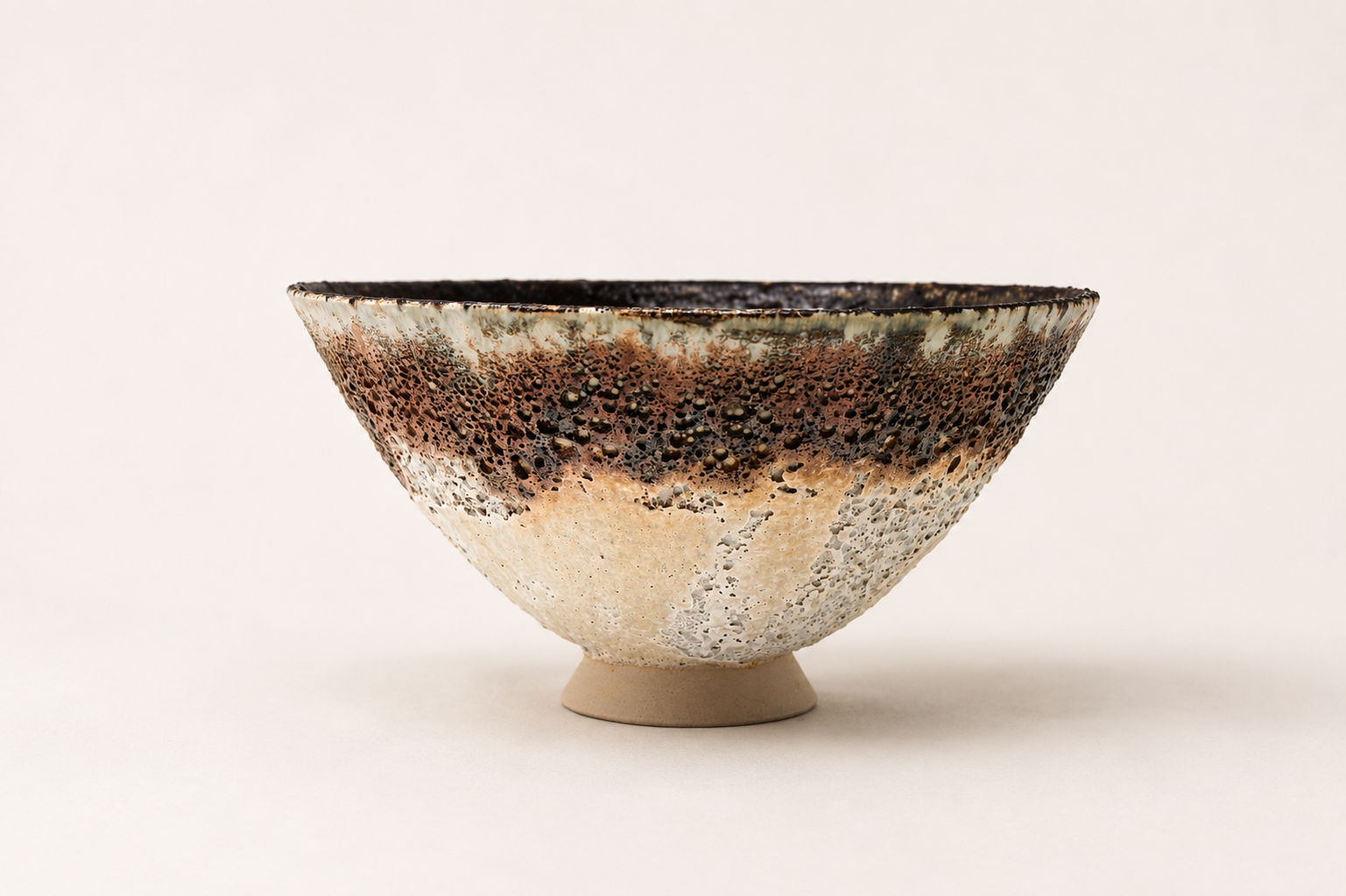 Wide V-shaped vessel with brown, cream and charcoal volcanic glazes