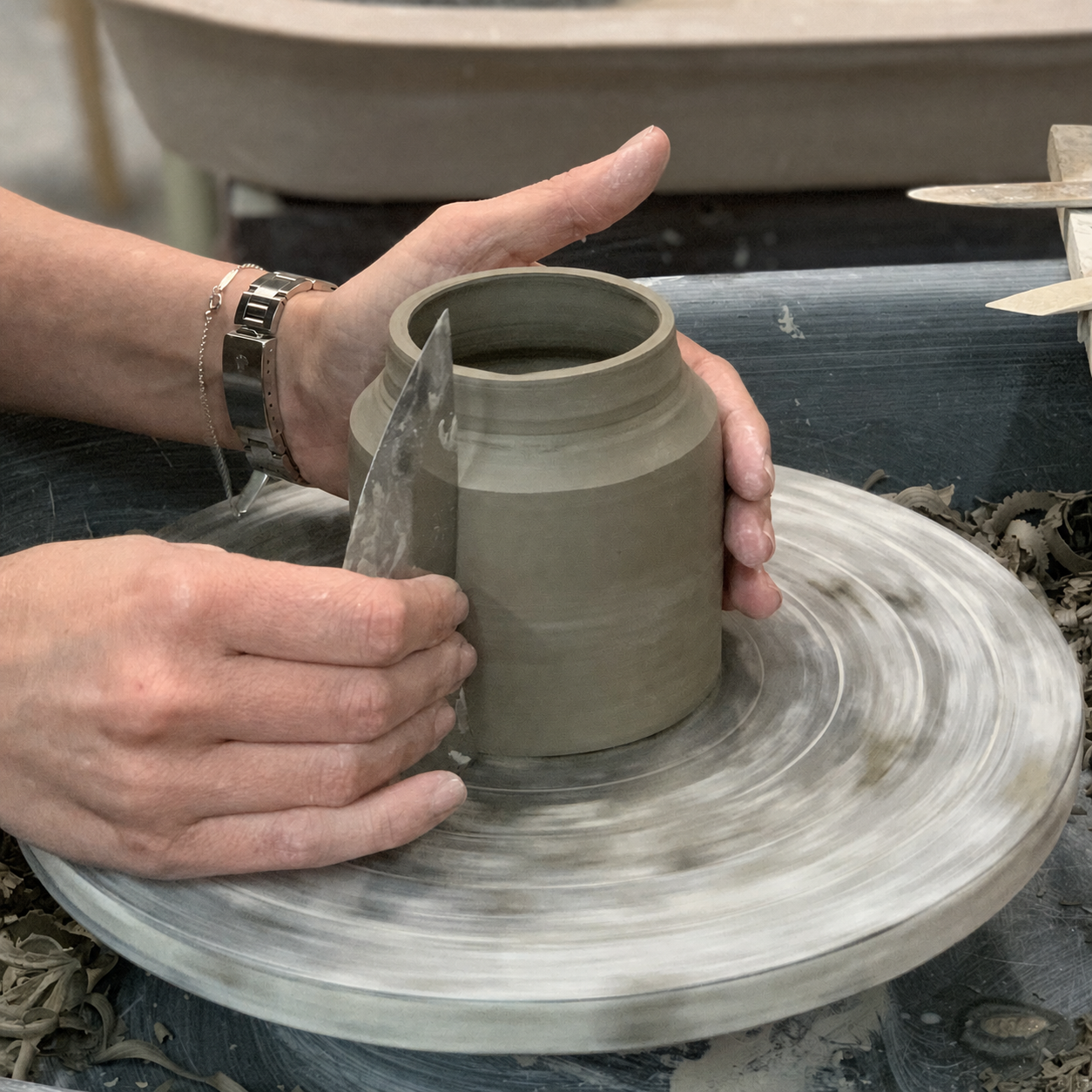Hands gently shaping clay on a pottery wheel